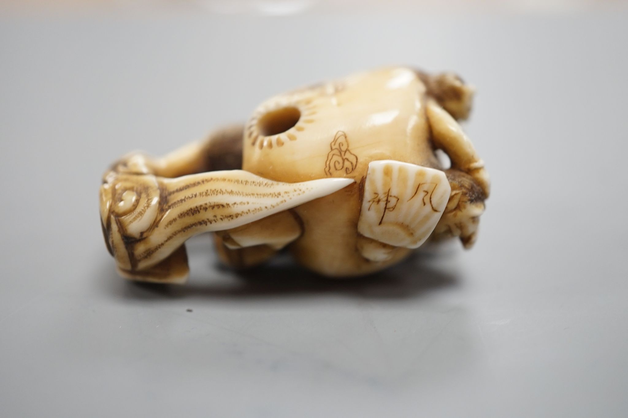 A Japanese ivory netsuke of oni, Meiji period, 4 cms high.